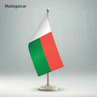 Flag of Madagascar hanging on a flag stand. vector