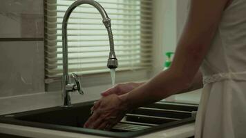 Close-up of woman's hand washing dishes at home video