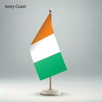 Flag of Ivory Coast hanging on a flag stand. vector