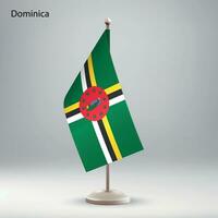 Flag of Dominica hanging on a flag stand. vector