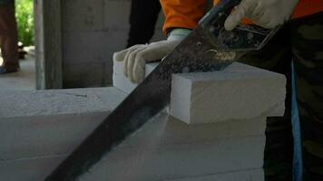Close-up of a worker's hand cutting lightweight bricks video