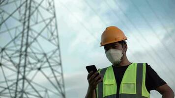 Aziatisch mannetje elektrisch ingenieur geven bestellingen door telefoon, hoog Spanning, buitenshuis video