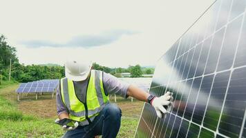 asiático hombre ingeniero utilizando digital tableta mantener solar célula paneles trabajando al aire libre en ecológico solar granja construcción. foto