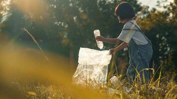 Kid Girl  collection plastic garbage in nature. kid picking up trash in park. photo