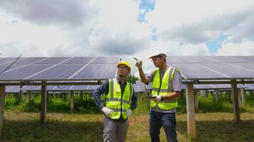 profesional asiático hombre ingeniero utilizando digital tableta mantener solar célula paneles juntos .técnico equipo trabajando en ecológico solar granja. foto