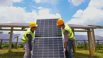 Two asian engineers installing solar panels . Solar energy clean and green alternative energy. Unity and teamwork. photo