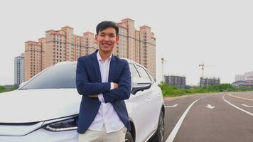 A business man standing to the car tall building background. photo