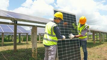 Two asian engineers installing solar panels . Solar energy clean and green alternative energy. Unity and teamwork. photo