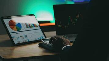 Financial Analyst Working on a Computer with Multi-Monitor Workstation with Real-Time Stocks, Commodities and Foreign Exchange Charts. Businessman Works in Investment Bank City Office at Night. video