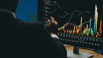 finanziell Analytiker Arbeiten auf ein Computer mit Multi-Monitor Arbeitsplatz mit Echtzeit Aktien, Waren und fremd Austausch Diagramme. Geschäftsmann funktioniert im Investition Bank Stadt Büro beim Nacht. video