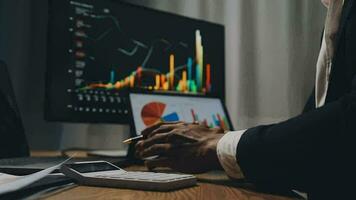 Financial Analyst Working on a Computer with Multi-Monitor Workstation with Real-Time Stocks, Commodities and Foreign Exchange Charts. Businessman Works in Investment Bank City Office at Night. video