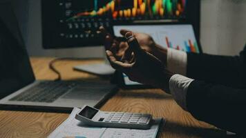 Financial Analyst Working on a Computer with Multi-Monitor Workstation with Real-Time Stocks, Commodities and Foreign Exchange Charts. Businessman Works in Investment Bank City Office at Night. video