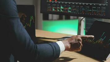 Businessman analyzing a graphic of a stock exchange chart. Back of the head of a young male businessman looking at a stock diagram on the big screen of the computer video