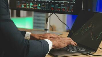 Businessman analyzing a graphic of a stock exchange chart. Back of the head of a young male businessman looking at a stock diagram on the big screen of the computer video