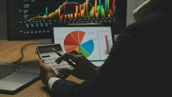 Businessman analyzing a graphic of a stock exchange chart. Back of the head of a young male businessman looking at a stock diagram on the big screen of the computer video