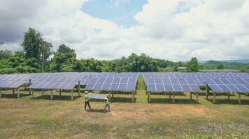 Two asian engineers installing solar panels . Solar energy clean and green alternative energy. Unity and teamwork. photo