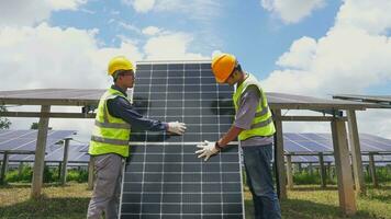 Two asian engineers installing solar panels . Solar energy clean and green alternative energy. Unity and teamwork. photo