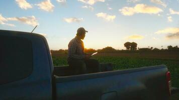 Asian young farmers and tobacco agriculturist utilize the core data network in the Internet from the tablet to validate, test in a tobacco field. photo