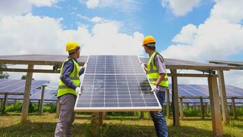 Two asian engineers installing solar panels . Solar energy clean and green alternative energy. Unity and teamwork. photo