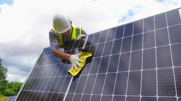 asiático ingeniero limpieza solar paneles a un edificio. foto