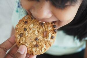 closeup of child mouth eating whole meal cookies photo