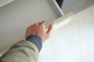 man's hand open drawer wooden in cabinet photo