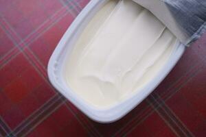 fresh butter in a container with bread on white background photo