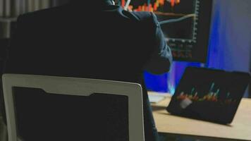 Businessman analyzing a graphic of a stock exchange chart. Back of the head of a young male businessman looking at a stock diagram on the big screen of the computer video