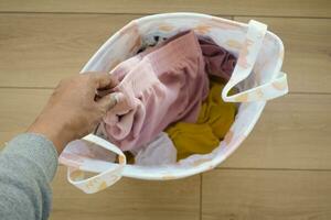 top view of putting Clothes in basket on floor photo