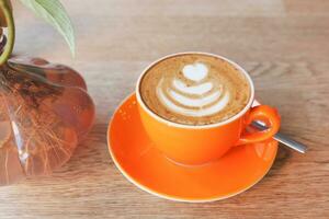 cup of hot coffee latte art on wooden background photo