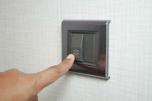 A finger turning on lighting switch . photo