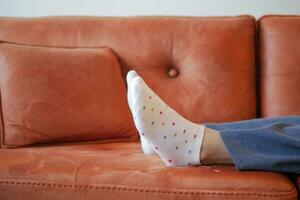 relax women feet lying on sofa in a bright house photo