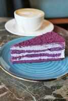 purple velvet cake with cream and coffee on table photo
