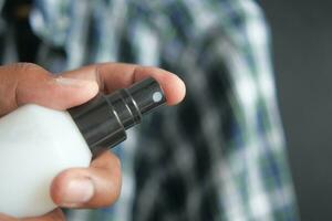 men uses stain remover spray for office shirt photo