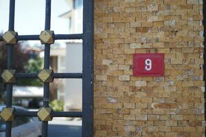 house number six. Decorative lettering on a brick wall. photo