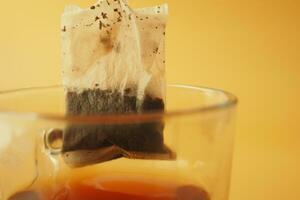 green tea and tea bag on table, close up. photo