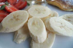 close up of slice of banana glass , strawberry and honey on a plate photo