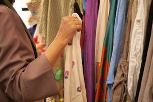 mujer elegir ropa en tienda. foto