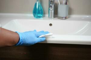 Hand in gloves cleaning the bathroom photo