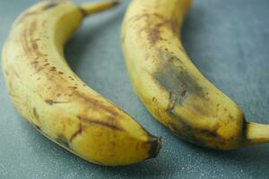 comparing rotten banana with a ripe banana on a white background photo