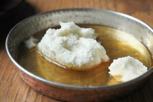 butter cream and honey in a bowl on table . photo