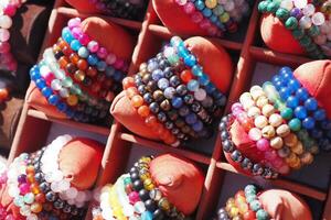 Bracelets with beads, laid out in the street market in the sun. photo