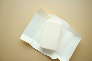 slice of a butter on a paper on table photo