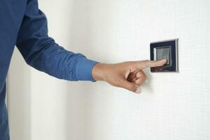 A finger turning on lighting switch . photo