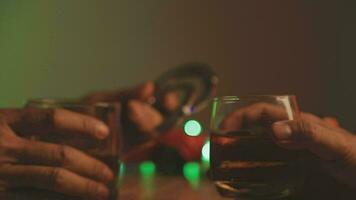 Close up of two people are cheering with cocktails in a bar or disco club. video