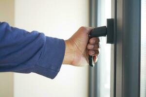 hand open gray plastic pvc window at home at early morning photo