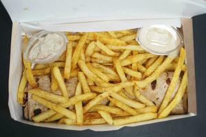 French Fries in a paper box on table photo