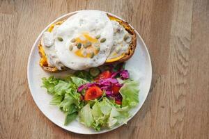 top view of Egg and mushrooms on toast served with fresh salad on a plate photo