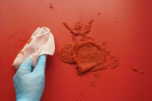 person hand cleaning tomato spill with a cloth photo