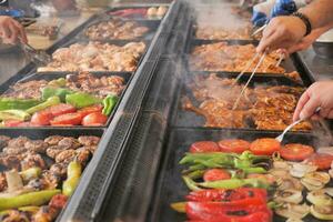 Beef and chicken steaks on the grill with flames. photo